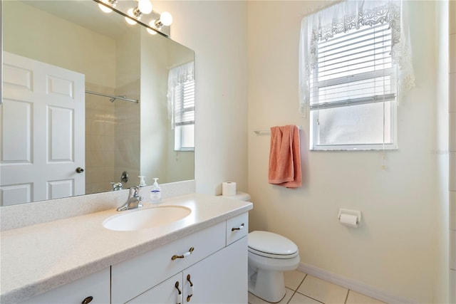 bathroom featuring a shower, toilet, vanity, baseboards, and tile patterned floors