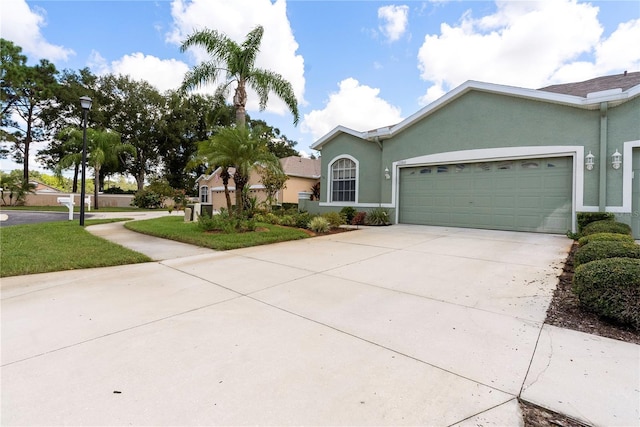 view of front of property featuring an attached garage, concrete driveway, and stucco siding