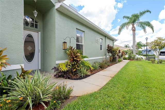 view of home's exterior featuring stucco siding and a yard