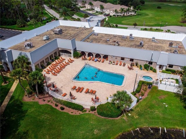 community pool with a patio area and a fenced backyard