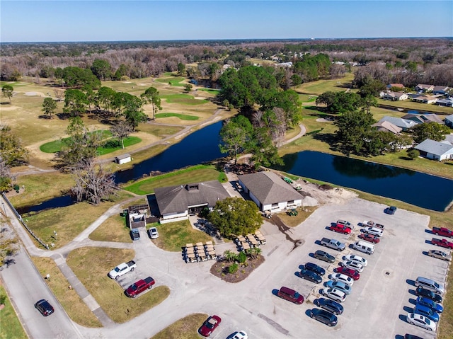 drone / aerial view with view of golf course and a water view