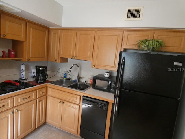 kitchen featuring backsplash, sink, light tile patterned floors, and black appliances