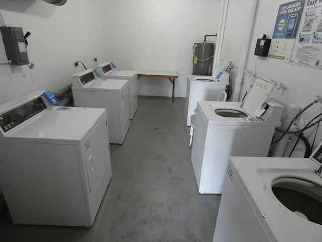 clothes washing area featuring secured water heater, electric panel, and washer and clothes dryer