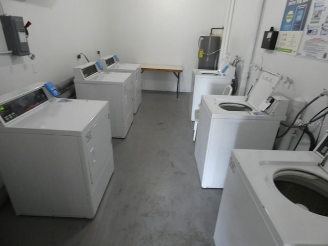 laundry room with secured water heater, separate washer and dryer, and electric panel