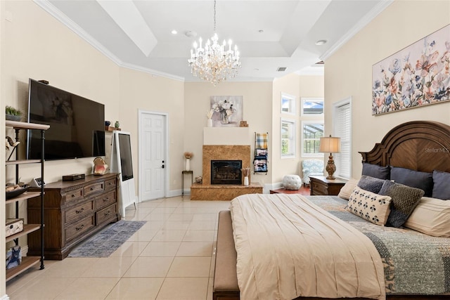 bedroom with light tile patterned floors, a fireplace, baseboards, ornamental molding, and a tray ceiling