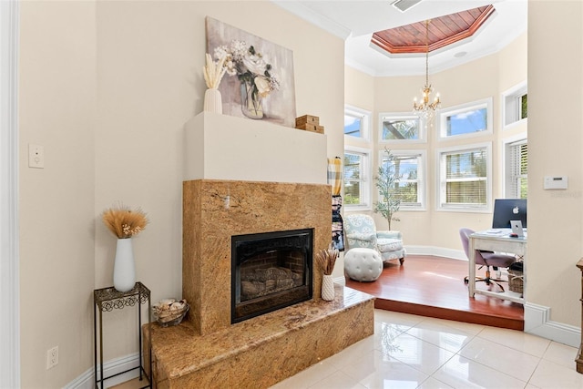 sitting room featuring baseboards, a premium fireplace, ornamental molding, and a notable chandelier