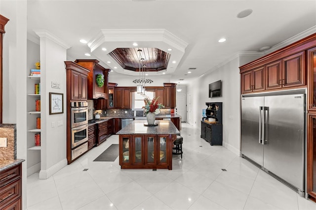 kitchen featuring stone countertops, appliances with stainless steel finishes, ornamental molding, a warming drawer, and a tray ceiling