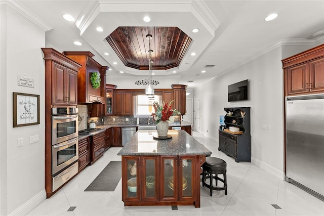 kitchen with stainless steel appliances, a tray ceiling, a kitchen island, and crown molding