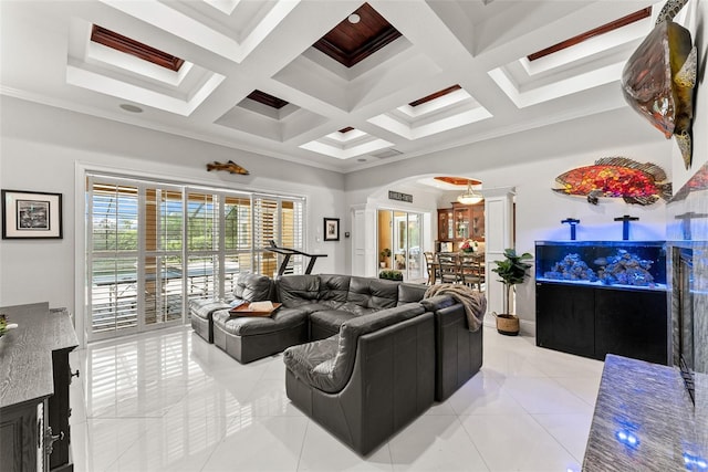 living room featuring arched walkways, coffered ceiling, crown molding, and light tile patterned floors