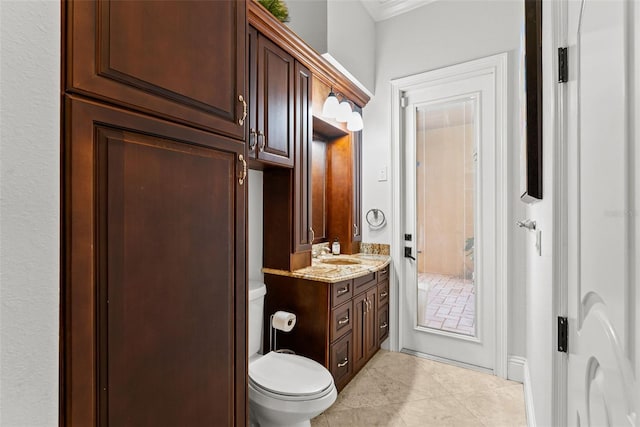 bathroom with tile patterned floors, vanity, toilet, and crown molding