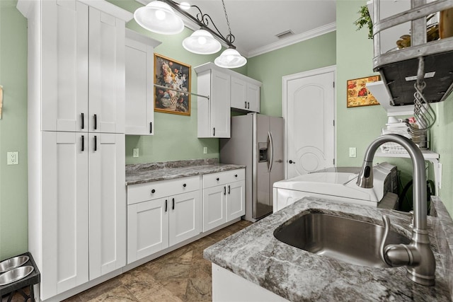 kitchen with stainless steel fridge, visible vents, white cabinetry, and ornamental molding