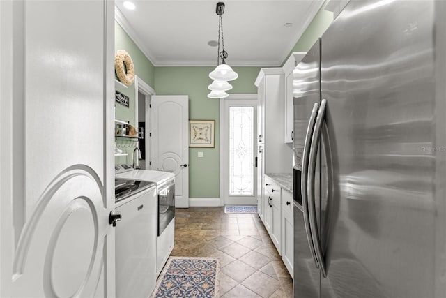 kitchen with ornamental molding, washing machine and dryer, white cabinetry, and stainless steel refrigerator with ice dispenser