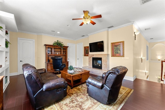 living room with a fireplace, wood finished floors, visible vents, and crown molding