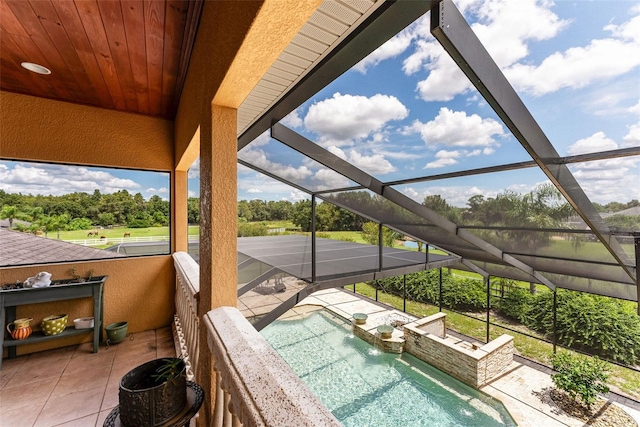 outdoor pool with glass enclosure and a patio