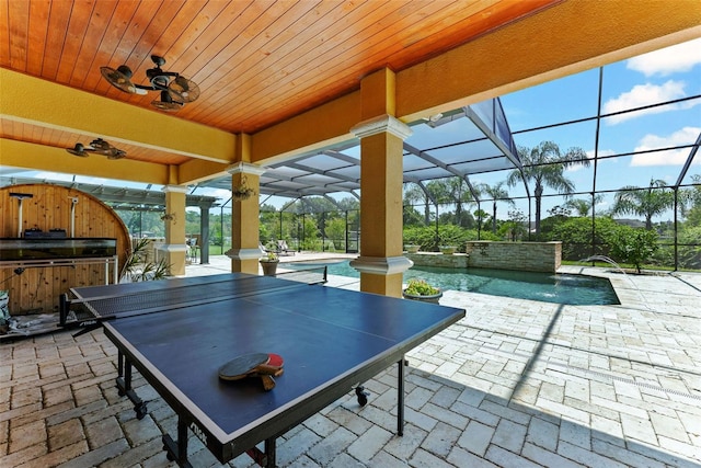 view of patio / terrace with a lanai, an outdoor pool, exterior kitchen, and outdoor dining space