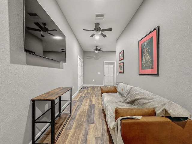 living room featuring wood finished floors, visible vents, and baseboards