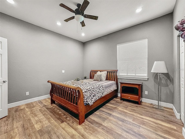 bedroom with recessed lighting, wood finished floors, and baseboards