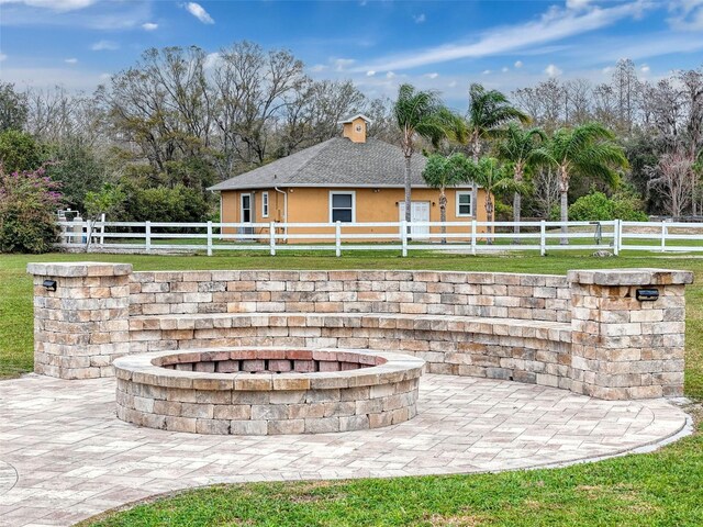 view of patio featuring a fenced front yard and an outdoor fire pit