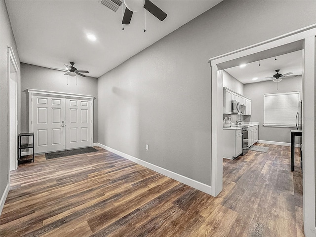 entryway with a ceiling fan, visible vents, dark wood finished floors, and baseboards