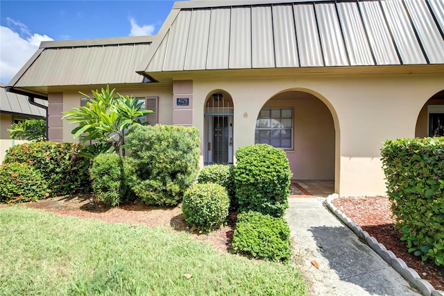 property entrance featuring a lawn