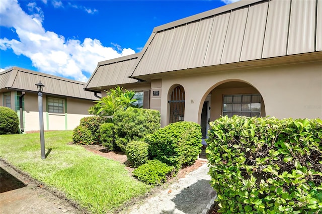 property entrance featuring a lawn