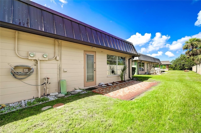 rear view of property featuring a lawn and a patio