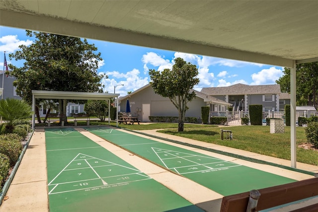 surrounding community featuring shuffleboard, a lawn, and fence