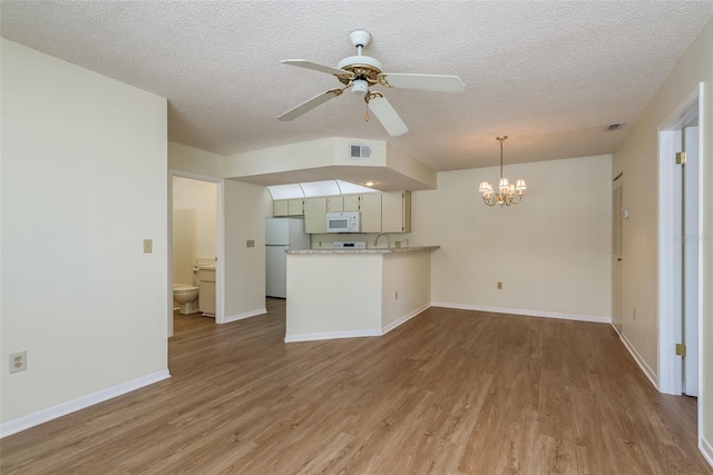 kitchen featuring a peninsula, white appliances, white cabinets, light countertops, and light wood finished floors