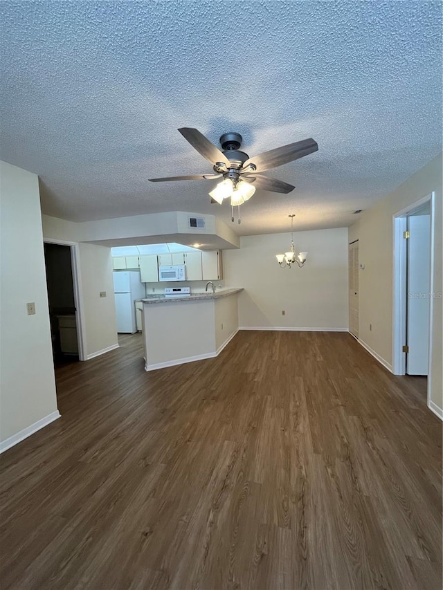 unfurnished living room with visible vents, baseboards, dark wood finished floors, a textured ceiling, and ceiling fan with notable chandelier