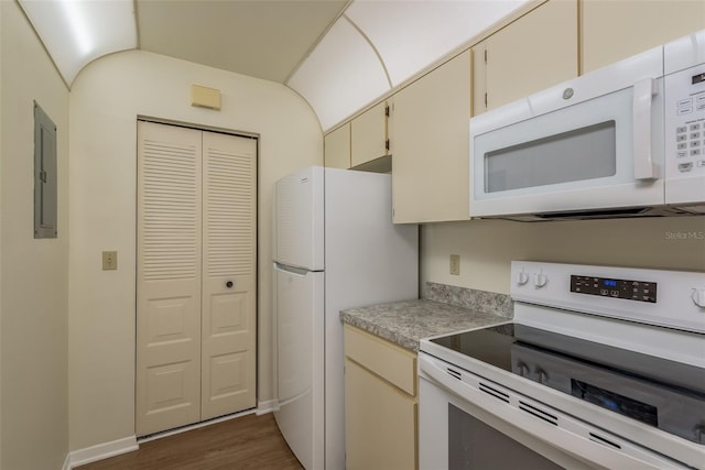 kitchen with cream cabinetry, light countertops, dark wood-type flooring, white appliances, and electric panel