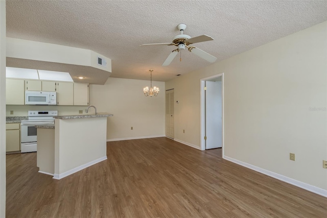 7712 Hillside Ct Unit 202, Hudson, FL 34667 - kitchen with white appliances, a chandelier, a ceiling fan, wood finished floors, and a textured ceiling
