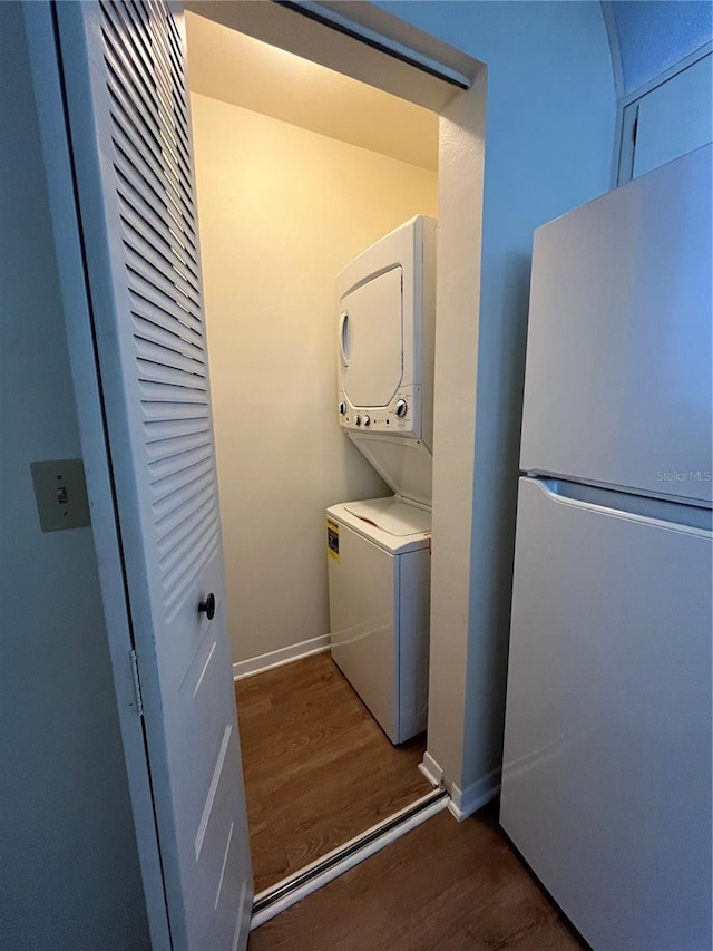 7712 Hillside Ct Unit 202, Hudson, FL 34667 - washroom with estacked washer and dryer, wood finished floors, and baseboards