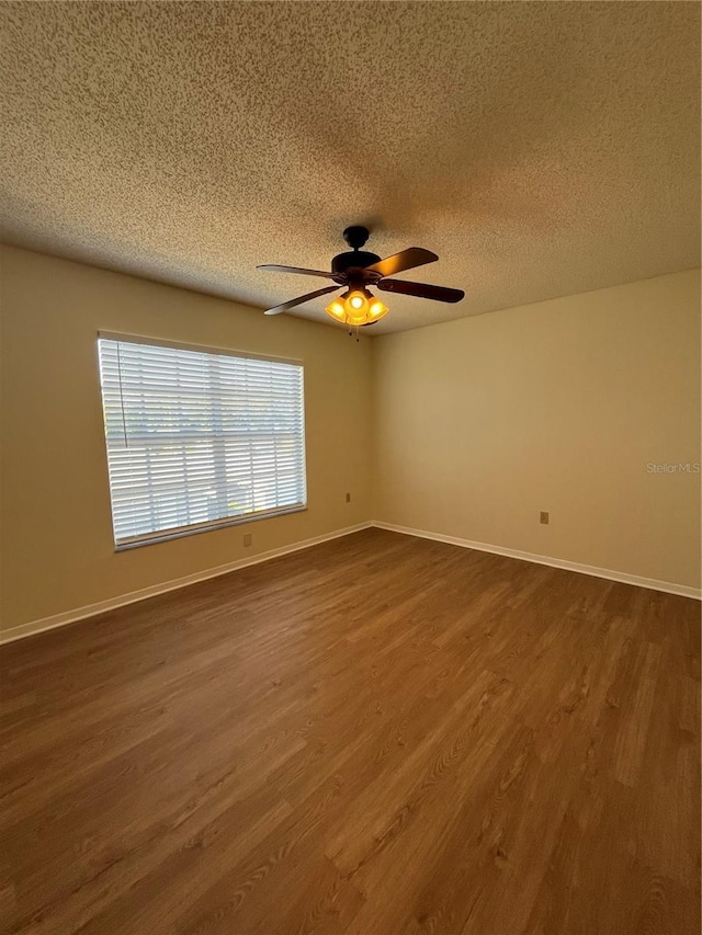 7712 Hillside Ct Unit 202, Hudson, FL 34667 - spare room with dark wood-style floors, ceiling fan, a textured ceiling, and baseboards