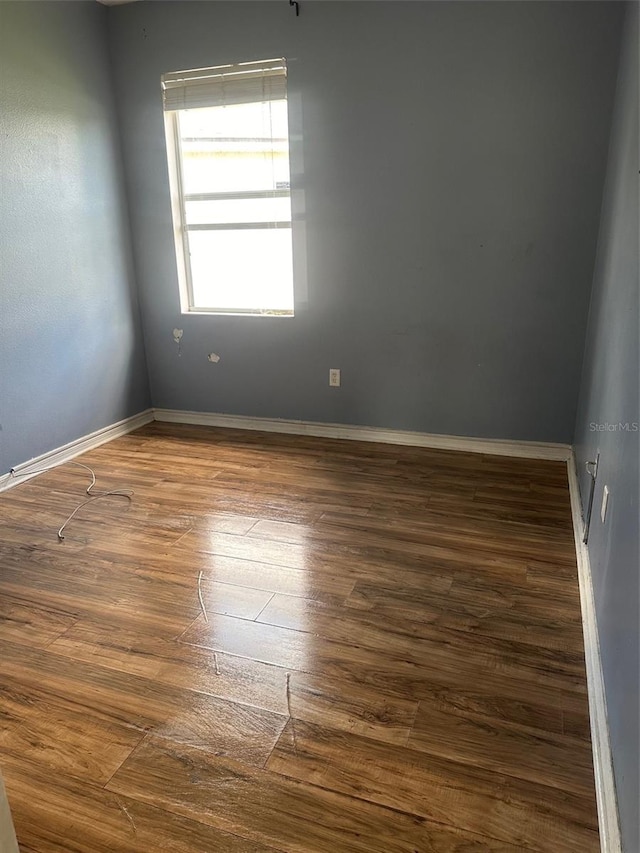 unfurnished room with dark hardwood / wood-style flooring