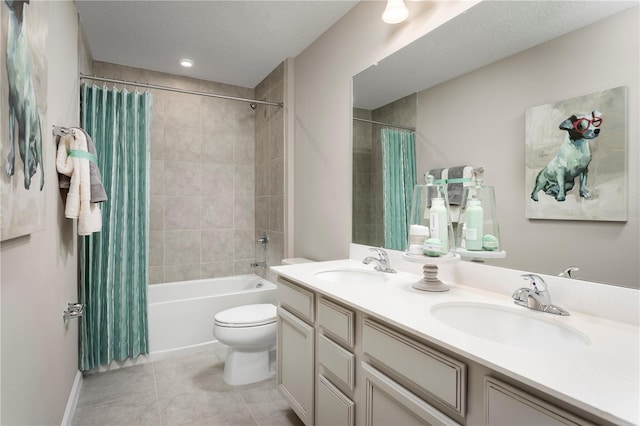 full bathroom featuring tile patterned floors, toilet, vanity, shower / bath combo with shower curtain, and a textured ceiling