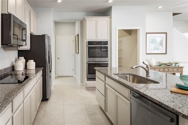 kitchen with appliances with stainless steel finishes, sink, and light stone countertops