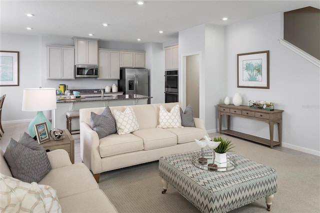 living room featuring sink and light colored carpet