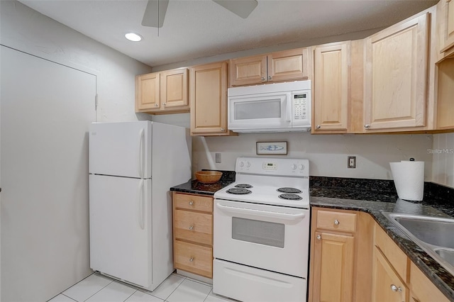 kitchen featuring dark stone counters, white appliances, light tile patterned floors, ceiling fan, and light brown cabinets