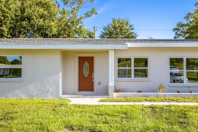 entrance to property featuring a yard