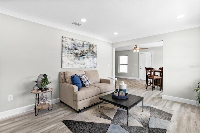 living room featuring ceiling fan and light wood-type flooring