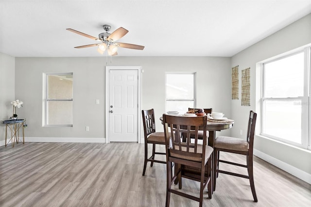 dining space with ceiling fan and light hardwood / wood-style floors