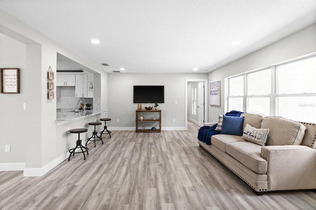 living room with light wood-type flooring and sink