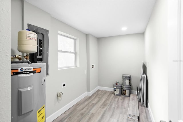 laundry area with light wood-type flooring, water heater, and electric dryer hookup