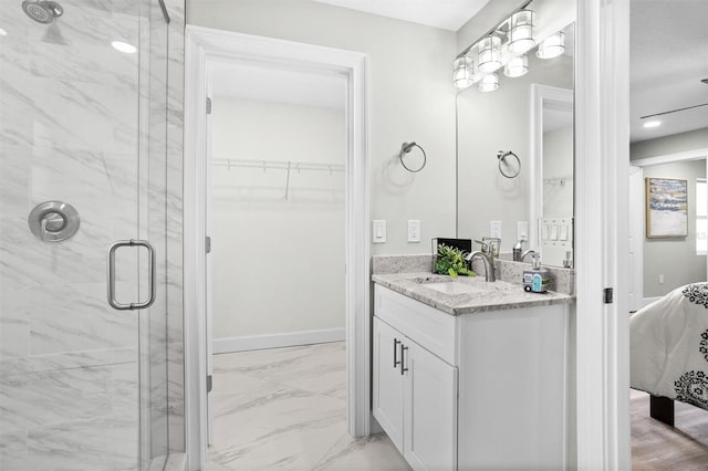 bathroom featuring a shower with door and vanity