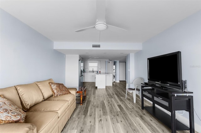 living room featuring light hardwood / wood-style flooring and ceiling fan