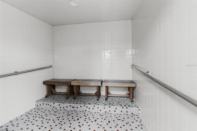 bathroom with tile patterned flooring and tile walls