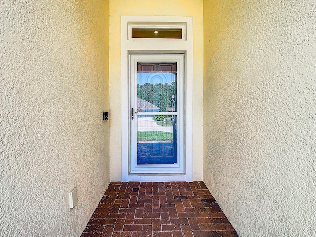 entrance to property with stucco siding