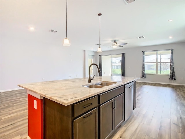 kitchen with light wood finished floors, visible vents, open floor plan, a sink, and stainless steel dishwasher