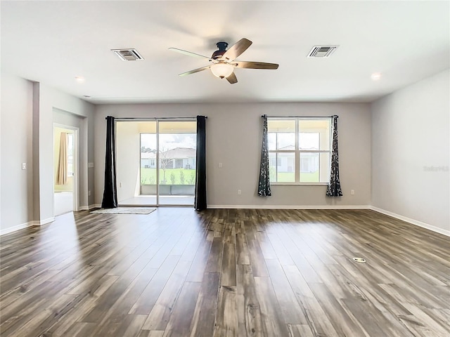 spare room featuring ceiling fan, baseboards, visible vents, and dark wood finished floors