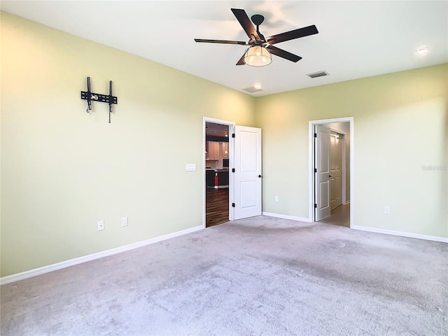 unfurnished bedroom featuring a ceiling fan, carpet, visible vents, and baseboards
